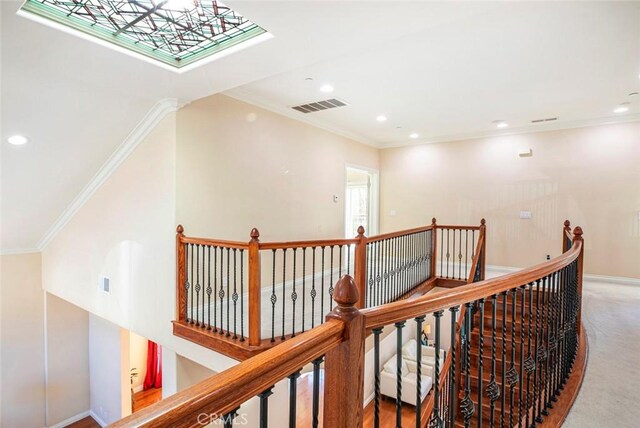 hall featuring ornamental molding and carpet