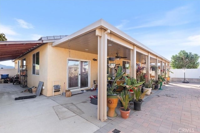 exterior space with ceiling fan and a patio