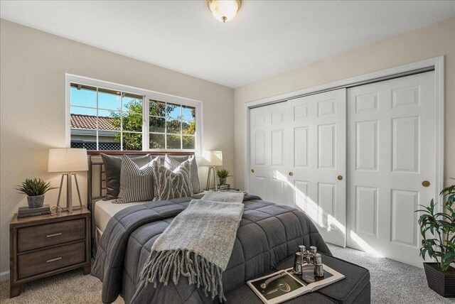 bedroom featuring light colored carpet and a closet