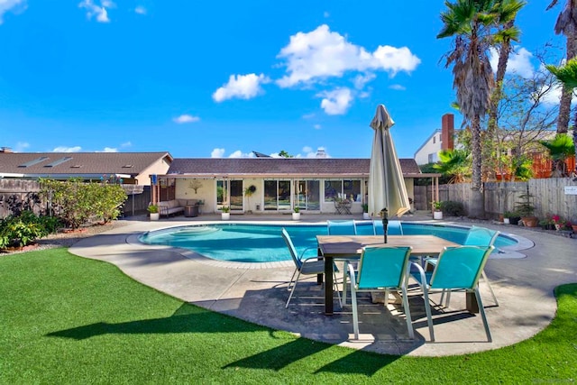 view of pool featuring a patio and a yard