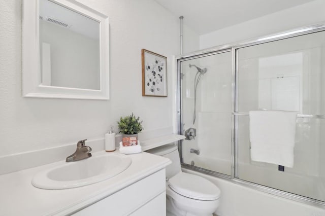 full bathroom with shower / bath combination with glass door, vanity, and toilet