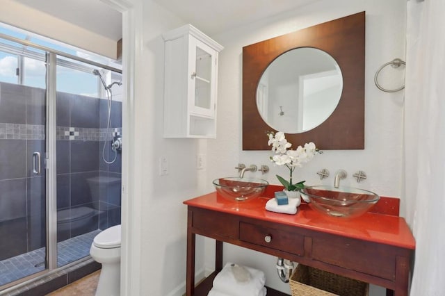 bathroom featuring toilet, a shower with door, and vanity