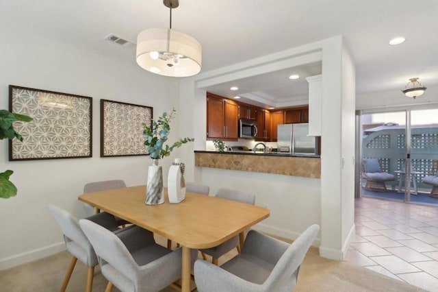 tiled dining area with a raised ceiling