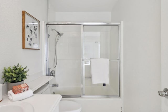 full bathroom featuring enclosed tub / shower combo, vanity, and toilet