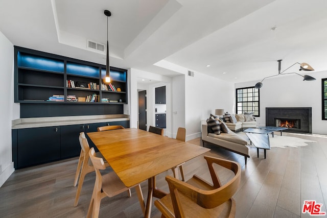 dining room with dark hardwood / wood-style flooring and built in features