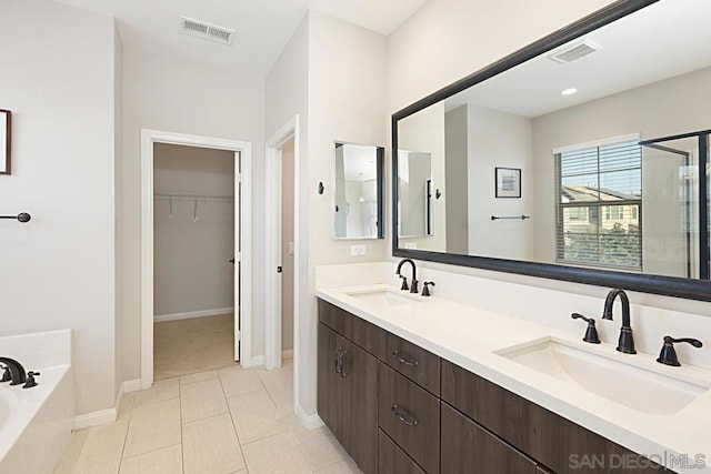 bathroom featuring vanity, tile patterned floors, and a bathing tub