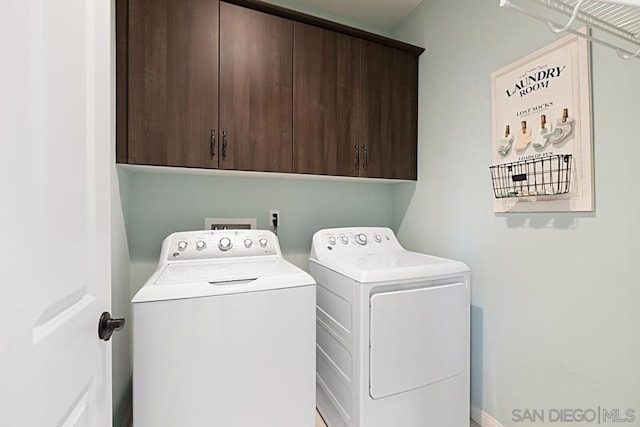 washroom featuring washing machine and dryer and cabinets