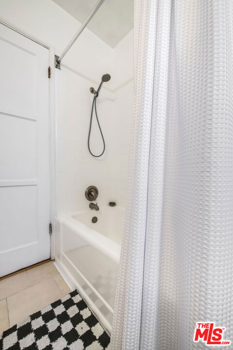 bathroom featuring shower / bathtub combination with curtain and tile patterned floors