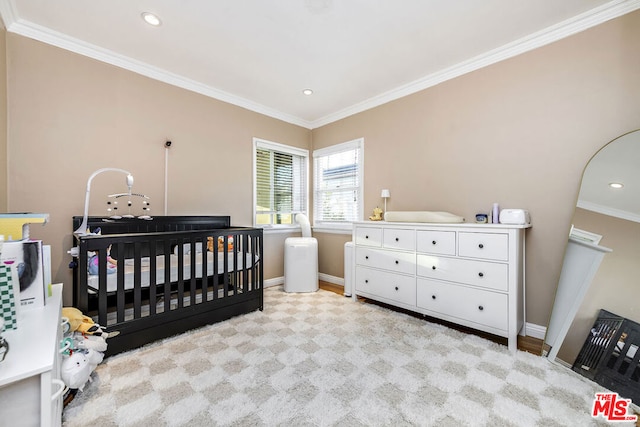 bedroom with a nursery area and ornamental molding