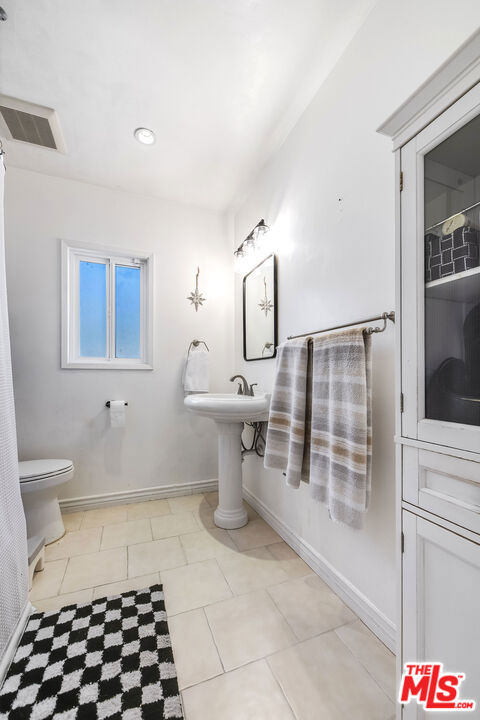 bathroom featuring toilet and tile patterned flooring