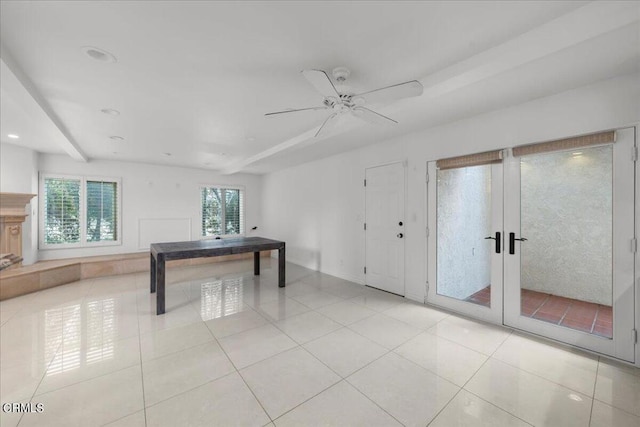 rec room with french doors, ceiling fan, light tile patterned floors, and beam ceiling