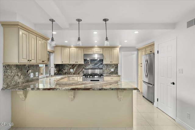 kitchen featuring stainless steel appliances, sink, pendant lighting, and kitchen peninsula