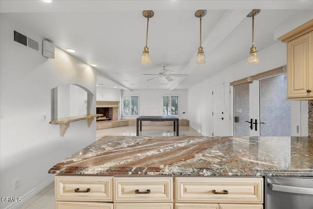 kitchen featuring decorative light fixtures, dark stone counters, ceiling fan, and stainless steel dishwasher