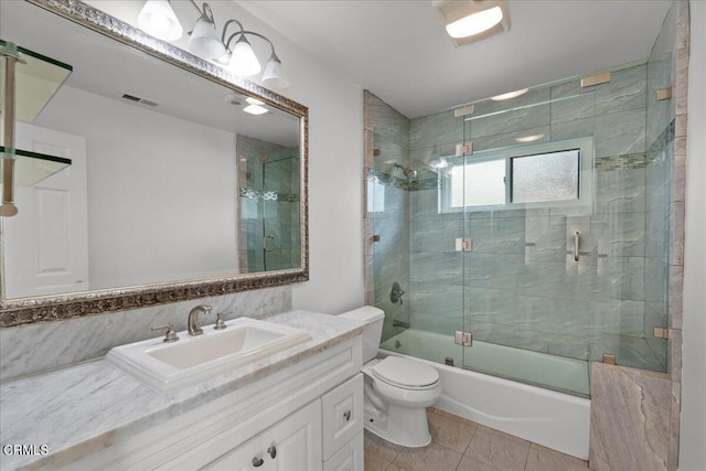 full bathroom with vanity, tile patterned flooring, shower / bath combination with glass door, and toilet