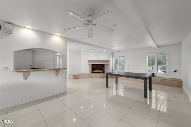 game room featuring ceiling fan, light tile patterned flooring, and beamed ceiling