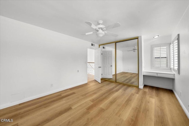 unfurnished bedroom featuring ceiling fan, light hardwood / wood-style floors, and a closet