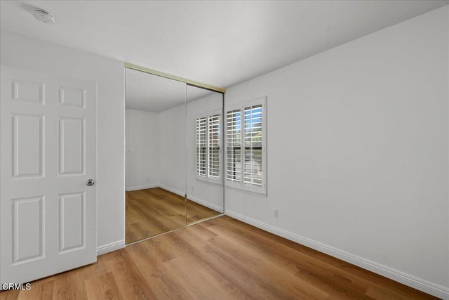 unfurnished bedroom featuring a closet and light hardwood / wood-style flooring