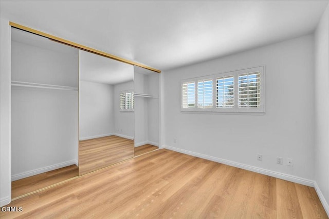 unfurnished bedroom featuring a closet and light hardwood / wood-style floors