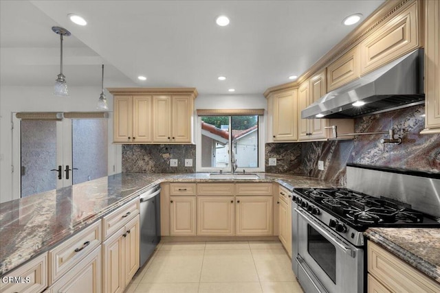 kitchen featuring sink, dark stone countertops, hanging light fixtures, ventilation hood, and appliances with stainless steel finishes