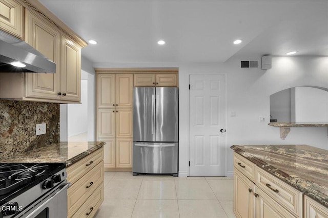 kitchen with extractor fan, backsplash, dark stone counters, and appliances with stainless steel finishes