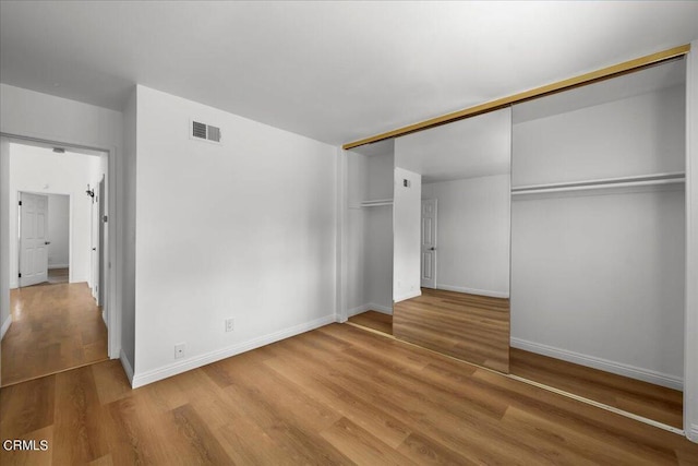 unfurnished bedroom featuring a closet and wood-type flooring