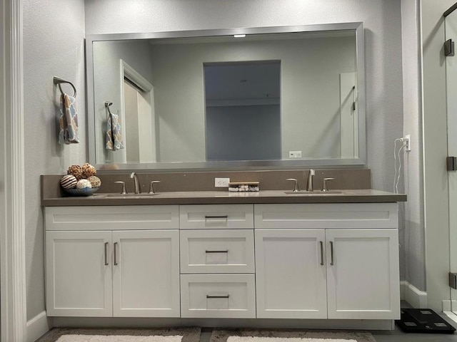 bathroom featuring a shower with door and vanity