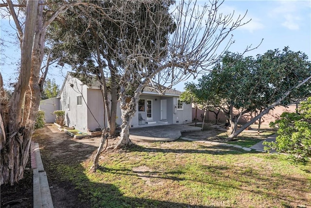 rear view of house featuring a lawn and a patio area