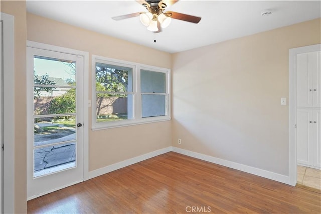 unfurnished room featuring ceiling fan, hardwood / wood-style floors, and a wealth of natural light