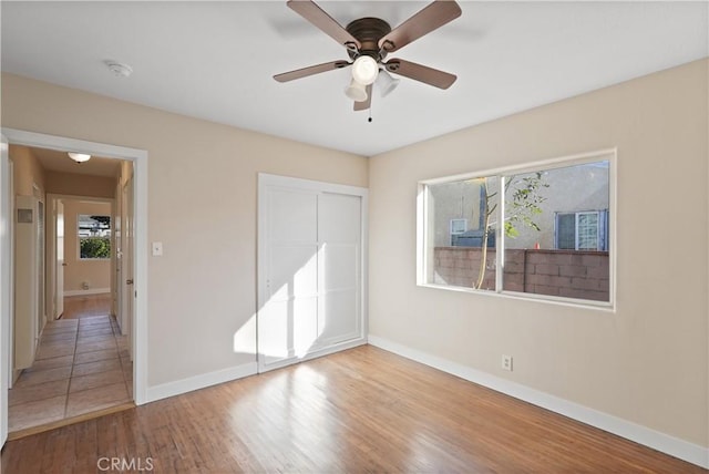 unfurnished bedroom with ceiling fan, light hardwood / wood-style flooring, and a closet