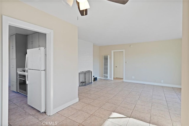 empty room featuring ceiling fan and light tile patterned floors