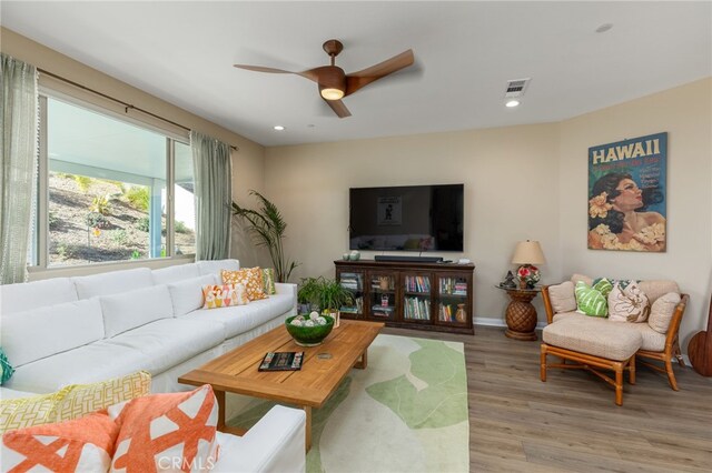 living room with ceiling fan and light hardwood / wood-style flooring