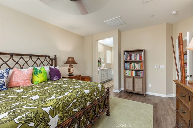 bedroom featuring ensuite bath, light wood-type flooring, and ceiling fan