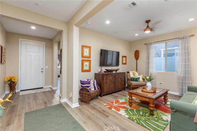 living room featuring ceiling fan and light hardwood / wood-style flooring