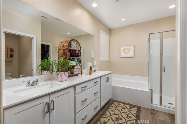 full bathroom featuring toilet, shower with separate bathtub, vanity, and hardwood / wood-style floors