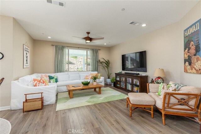 living room with light wood-type flooring and ceiling fan