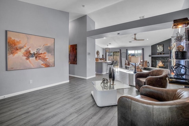 living room featuring lofted ceiling, a high end fireplace, ceiling fan, and hardwood / wood-style flooring