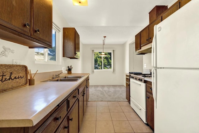 kitchen with sink, white appliances, light tile patterned floors, and hanging light fixtures