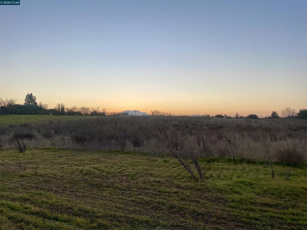 yard at dusk with a rural view