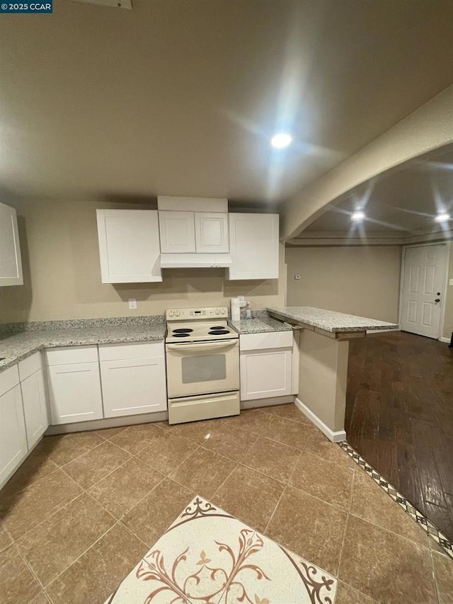 kitchen with electric range, white cabinets, and light stone counters