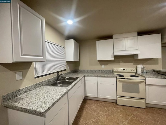 kitchen with sink, electric range, light tile patterned floors, and white cabinetry