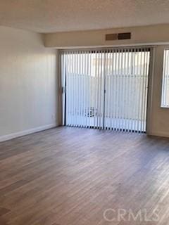 empty room with hardwood / wood-style flooring and plenty of natural light