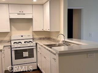 kitchen with white range with gas cooktop, white cabinetry, sink, and kitchen peninsula