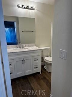 bathroom featuring toilet, vanity, and wood-type flooring