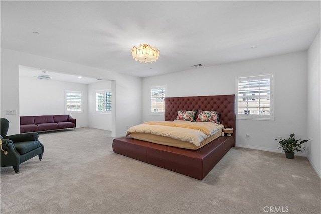 bedroom with light colored carpet and multiple windows