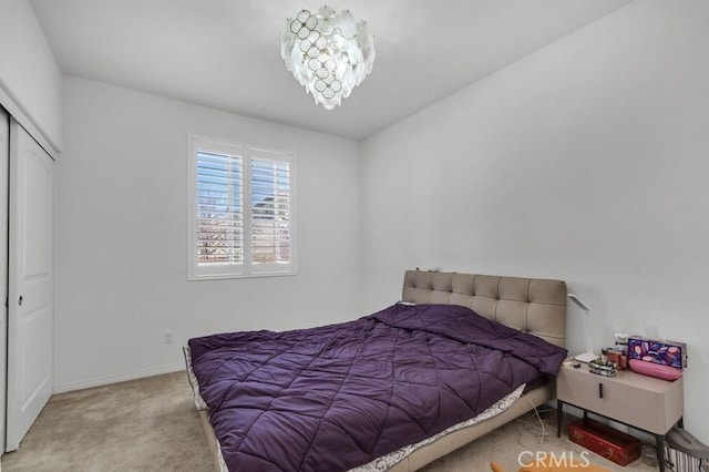 bedroom featuring a notable chandelier, a closet, and carpet