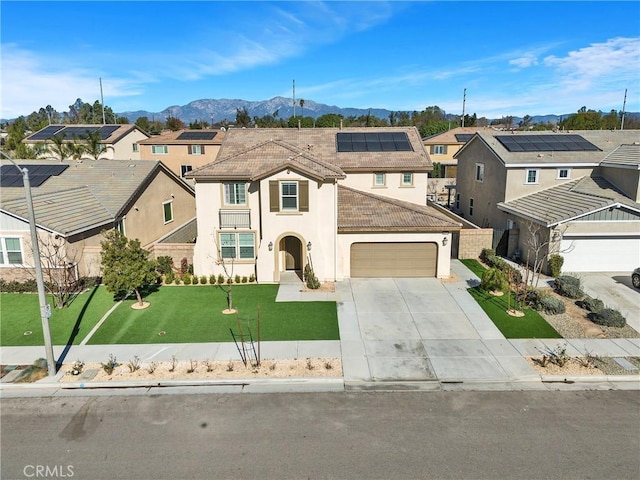 view of front of house with solar panels, a mountain view, a front yard, and a garage