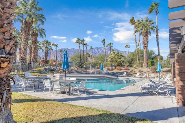 view of swimming pool with a mountain view and a patio