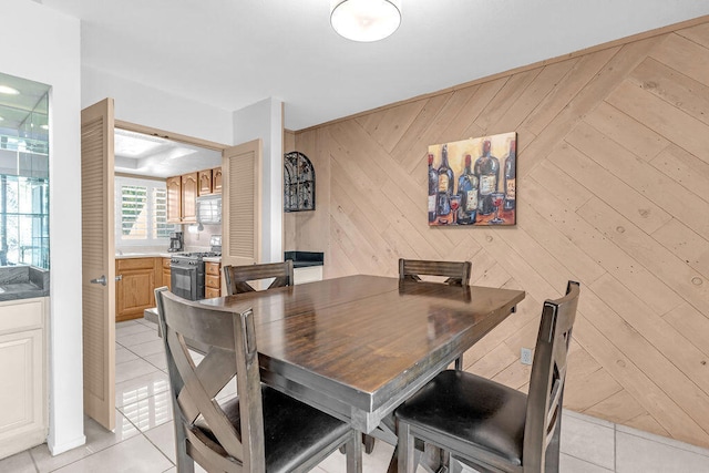 tiled dining room featuring wooden walls