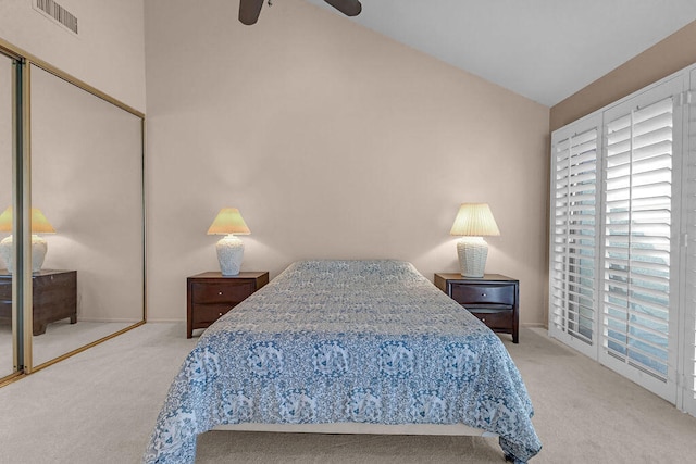 bedroom with ceiling fan, lofted ceiling, a closet, and carpet flooring