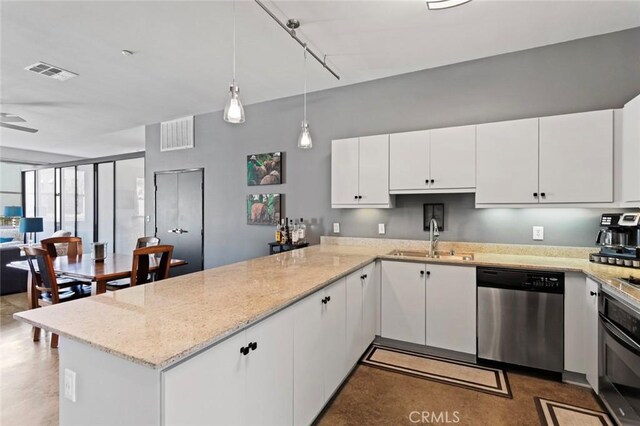 kitchen featuring stainless steel dishwasher, wall oven, rail lighting, white cabinets, and sink